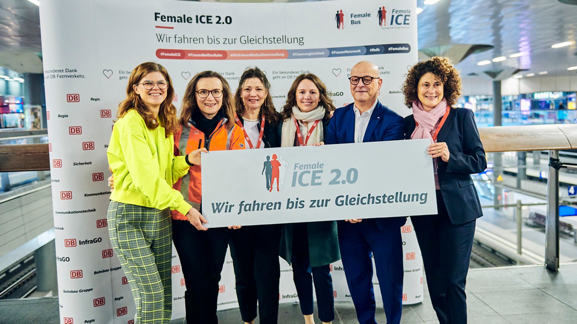 Vorständ:innen und Projektleiterinnen des Female iCE zeigen das Schild "Wir fahren bis zur Gleichstellung" 